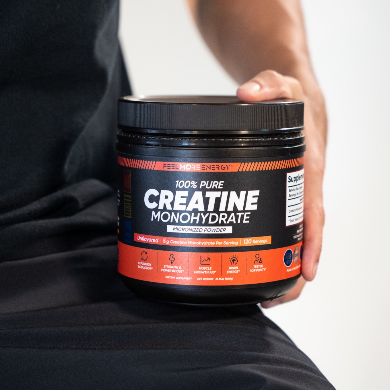 Athlete with Feel More Energy creatine monohydrate jars at the gym — clinical-grade fuel for strength training