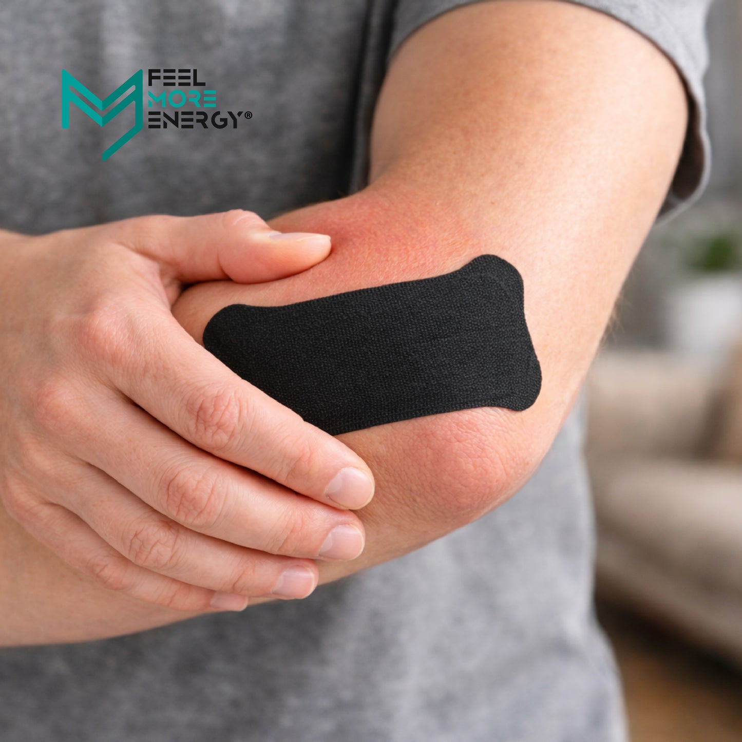 Person with a black bandage on their elbow, featuring 'Feel More Energy' logo.