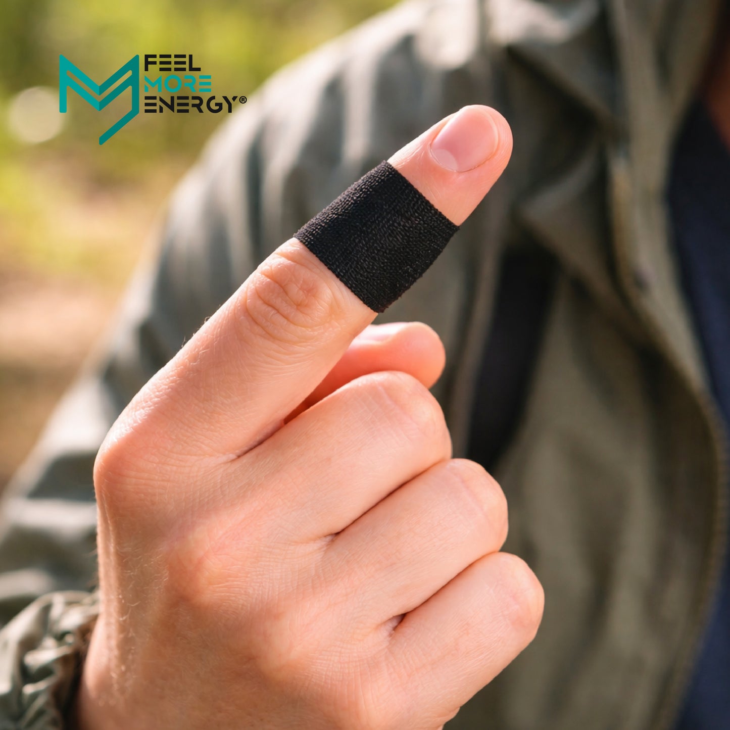Person wearing a black finger band with 'Feel More Energy' branding.