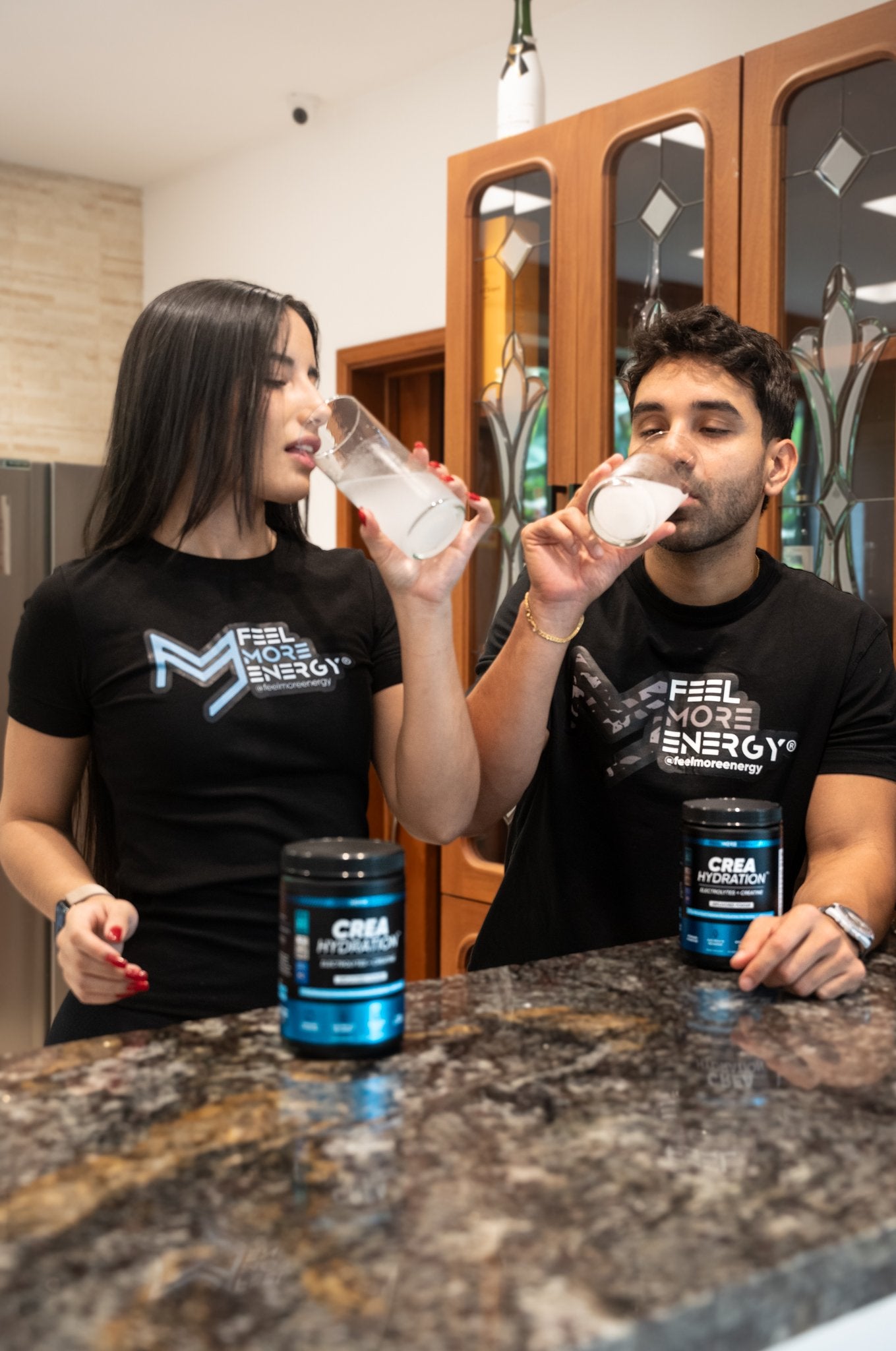Two people in a kitchen drinking their Feel More Energy shakes